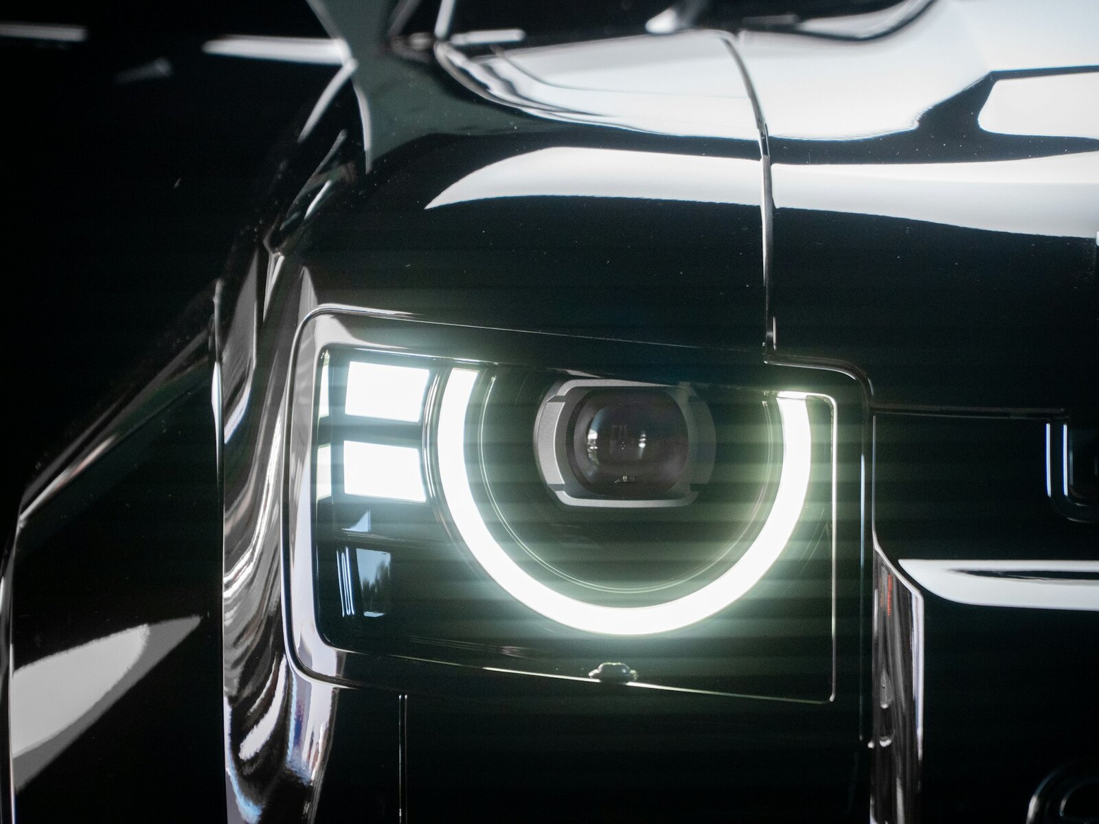 Glowing headlight on freshly corrected black paint under studio light